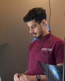 Dr Ahmad Mahmood in maroon scrubs embroidered with his name and "Consultant Endodontist"