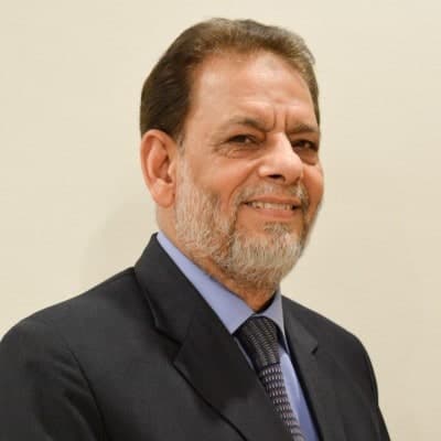 Prof. Dr Amjad Mahmood, founder of Dental Plus, in a dark suit and tie